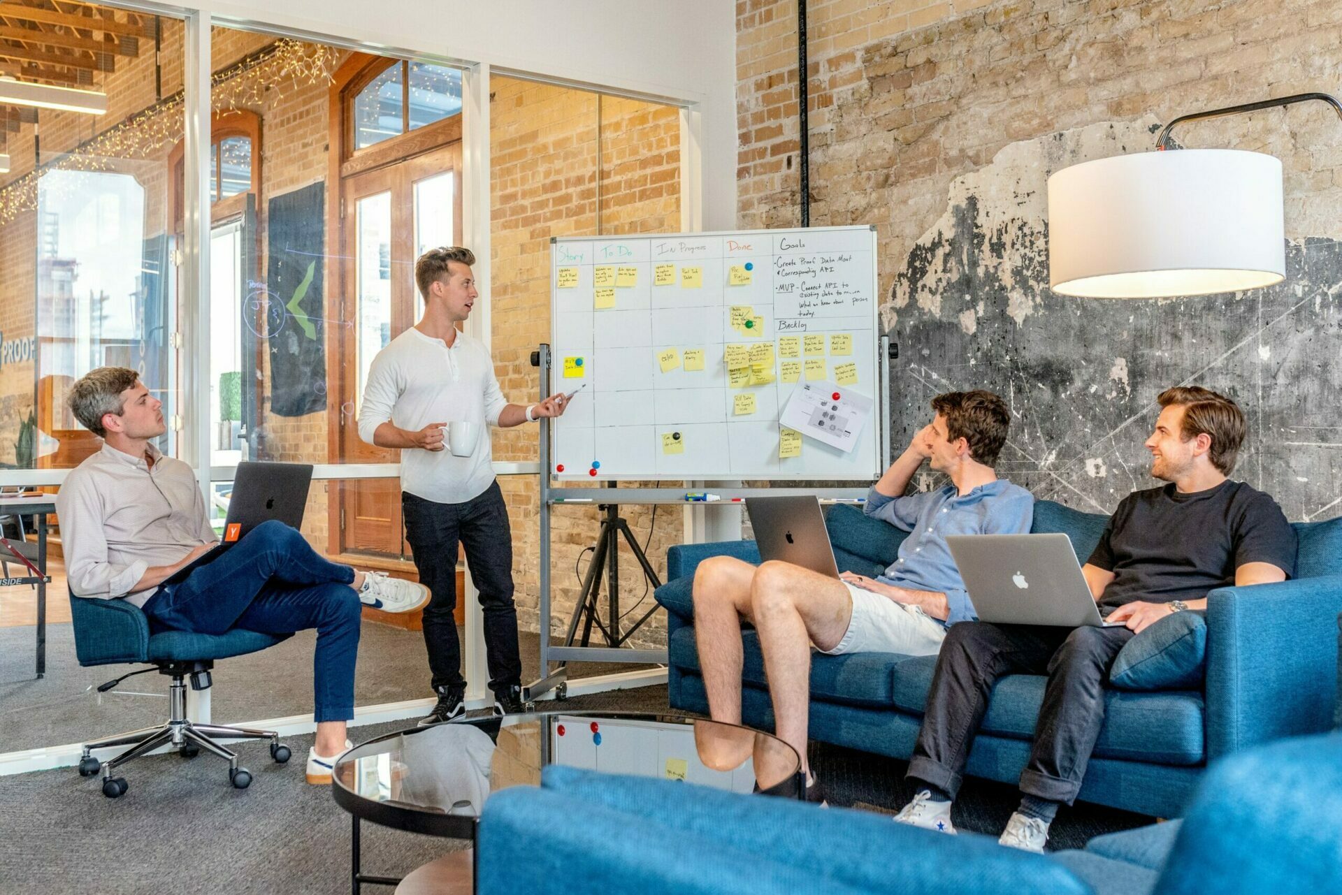 austin-distel-wD1LRb9OeEo-unsplash Vier junge Männer in legerer Kleidung in einem Business-Meeting.