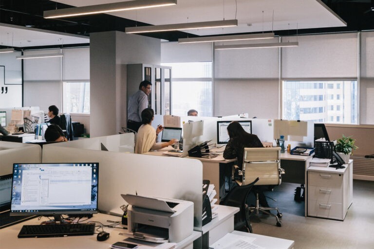 Eine Gruppe Mitarbeiter im Gespräch im Büro. Foto zum Thema Wissensmanagement für Unternehmen.